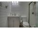 Modern bathroom featuring shiplap accent walls, updated vanity, toilet, and glass enclosed shower at 480 Friar Tuck Cir, Covington, GA 30014
