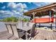 Covered boat dock with boat lift featuring an outdoor dining table set perfect for lakeside entertaining and relaxation at 480 Friar Tuck Cir, Covington, GA 30014