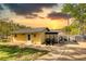 Charming waterfront home featuring a metal roof and cozy entrance surrounded by lush greenery at sunset at 480 Friar Tuck Cir, Covington, GA 30014