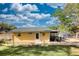 Charming yellow home with a green metal roof, complemented by a well-maintained lawn and a beautiful wreath on the front door at 480 Friar Tuck Cir, Covington, GA 30014