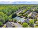 Aerial view showcasing townhomes, surrounded by lush trees, tennis courts, and a community pool at 12150 Dancliff Trce, Alpharetta, GA 30009