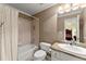 Well-lit bathroom features a shower over bath, toilet, and granite vanity countertop at 12150 Dancliff Trce, Alpharetta, GA 30009