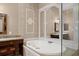 Elegant bathroom with a jetted tub, granite countertop vanity, and decorative mirror at 12150 Dancliff Trce, Alpharetta, GA 30009