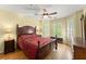 A cozy bedroom with a ceiling fan, hardwood floors, and natural light from the windows at 12150 Dancliff Trce, Alpharetta, GA 30009