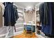 Walk-in closet with custom shelving, sewing machine and a variety of clothing at 12150 Dancliff Trce, Alpharetta, GA 30009