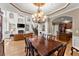 Elegant dining room with a large chandelier and a view of the living room and kitchen at 12150 Dancliff Trce, Alpharetta, GA 30009