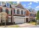 A traditional brick townhome featuring a two-car garage and well-manicured landscaping at 12150 Dancliff Trce, Alpharetta, GA 30009
