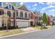 Charming brick townhome featuring a two-car garage, black shutters, and manicured landscaping at 12150 Dancliff Trce, Alpharetta, GA 30009