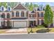 A brick townhome with a front-facing two-car garage and a well-maintained lawn at 12150 Dancliff Trce, Alpharetta, GA 30009