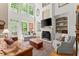 Spacious living room with soaring windows, a fireplace, custom built-ins, and comfortable seating for relaxing and entertaining at 12150 Dancliff Trce, Alpharetta, GA 30009