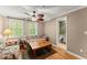 Comfortable living room featuring hardwood floors, ceiling fan and access to an adjoining bathroom at 12150 Dancliff Trce, Alpharetta, GA 30009