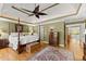Spacious main bedroom with hardwood floors, recessed lighting, sitting area, and four-poster bed at 12150 Dancliff Trce, Alpharetta, GA 30009