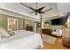 Main bedroom with hardwood floors, a ceiling fan, large bed, and a cozy sitting area at 12150 Dancliff Trce, Alpharetta, GA 30009