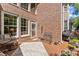 Cozy outdoor patio with brick walls, seating and access to the backyard, perfect for relaxing and entertaining at 12150 Dancliff Trce, Alpharetta, GA 30009