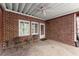 Covered patio with red brick walls, ceiling fan, stone floor and outdoor seating area at 12150 Dancliff Trce, Alpharetta, GA 30009