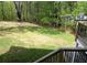 Lush green backyard view from the wood deck with railings, featuring mature trees and lawn at 1521 Larkwood Dr, Canton, GA 30114