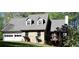 Charming home with a two-car garage, stone facade, and a cozy deck surrounded by lush greenery at 1521 Larkwood Dr, Canton, GA 30114