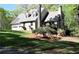 Charming home with a two-car garage, stone facade, and a cozy deck surrounded by lush greenery at 1521 Larkwood Dr, Canton, GA 30114
