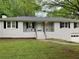 Charming home with a white brick facade, black shutters, and a well-maintained lawn at 1871 Kinridge Rd, Marietta, GA 30062