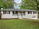 Charming home with a white brick facade, black shutters, and a well-maintained lawn at 1871 Kinridge Rd, Marietta, GA 30062
