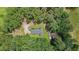 Bird's-eye view of a home with wooded acreage, accessory buildings, and circular driveway at 527 Gaddis Rd, Canton, GA 30115