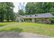 Charming brick home with dormer windows, inviting front porch, and lush landscaping at 527 Gaddis Rd, Canton, GA 30115