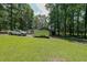 Exterior property view with trucks, trailers, shed, and surrounded by many trees at 527 Gaddis Rd, Canton, GA 30115