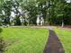 Lush green front yard with a walkway and trees at 527 Gaddis Rd, Canton, GA 30115