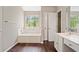 Bathroom with a modern sink vanity, bathtub under a window, and a separate toilet area at 610 Durham Ridge Nw Dr, Lilburn, GA 30047