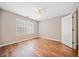 Well-lit bedroom with hardwood floors, ceiling fan, and large window at 610 Durham Ridge Nw Dr, Lilburn, GA 30047