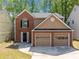 A close up of a two-story home with a brick and brown exterior, and a two-car garage at 610 Durham Ridge Nw Dr, Lilburn, GA 30047