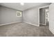 A bright bedroom with neutral carpet, gray walls, and a window providing natural light and ventilation at 1971 Westley Dr, Riverdale, GA 30296