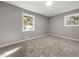 A well-lit bedroom with neutral carpet and gray walls, illuminated by natural light streaming through windows at 1971 Westley Dr, Riverdale, GA 30296