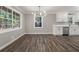 Stylish living room features wood-look flooring, modern lighting, and a view into the adjacent kitchen at 1971 Westley Dr, Riverdale, GA 30296