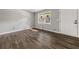 Well-lit living room featuring wood-look flooring, a large window, and a crisp white door at 1971 Westley Dr, Riverdale, GA 30296