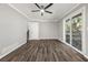 Large living room with wood-look floors, neutral paint, sliding glass doors to back deck, and ceiling fan at 1971 Westley Dr, Riverdale, GA 30296