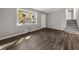 Open living area features wood-look floors, gray walls, a large window, and convenient access to the stairs at 1971 Westley Dr, Riverdale, GA 30296