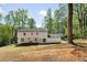 Backyard view of the home's white siding, windows and door, patio and surrounding trees at 220 Hobnail Se Ct, Marietta, GA 30067
