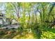 Beautifully landscaped backyard with a lush lawn, mature trees, and a charming deck area, perfect for outdoor entertaining at 3727 Cline Se Dr, Smyrna, GA 30082