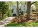 Beautiful home exterior featuring mature trees, flowering shrubs, a quaint water fountain, and a long driveway at 3727 Cline Se Dr, Smyrna, GA 30082