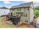 Exterior view of the home showcasing a spacious deck, patio, and a well-maintained lawn at 626 Oakbourne Way, Woodstock, GA 30188