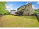 A spacious backyard with a lush green lawn, deck, mature trees, and privacy fencing at 626 Oakbourne Way, Woodstock, GA 30188