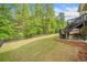 Grassy backyard features a patio with seating, an outdoor grill, and a wood fence at 626 Oakbourne Way, Woodstock, GA 30188