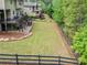 Large backyard with a deck, patio, wooden fence, and steps leading to a fire pit at 626 Oakbourne Way, Woodstock, GA 30188
