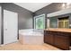 Bathroom featuring a soaking tub, dual sink vanity, and stained glass window at 626 Oakbourne Way, Woodstock, GA 30188