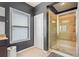 Bathroom featuring tiled shower, white door and window at 626 Oakbourne Way, Woodstock, GA 30188