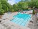 A large swimming pool is surrounded by lush landscaping and features a slide, fountains, and plenty of space at 626 Oakbourne Way, Woodstock, GA 30188