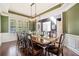 Elegant dining room featuring wainscoting, stylish light fixture, and a long table for gatherings at 626 Oakbourne Way, Woodstock, GA 30188