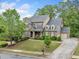 Charming two-story brick home featuring well-maintained landscaping and a long driveway at 626 Oakbourne Way, Woodstock, GA 30188