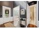 Elegant foyer with hardwood floors, decorative table, and access to living spaces and bathroom at 626 Oakbourne Way, Woodstock, GA 30188